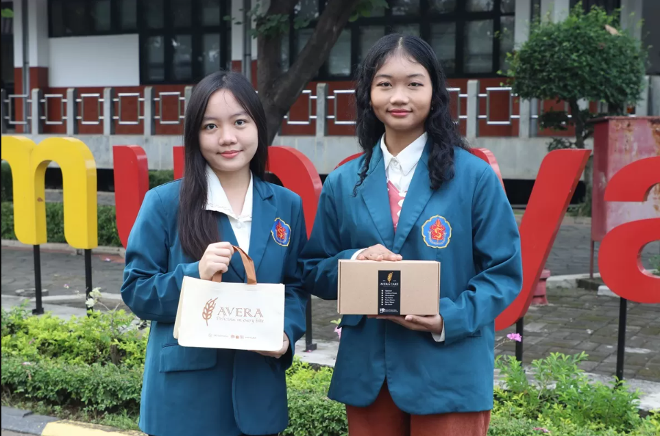 Dua mahasiswa Universitas Surabaya (Ubaya), Patricia Esther Wellyana (kiri) dan Alodia Ardine Ardiningrum (kanan), menunjukkan produk kue lapis premium Avera Cake yang mereka rintis. (dok. Ubaya)